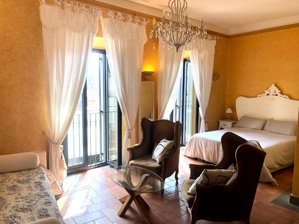 a bedroom with a bed and two chairs at S. Faustino Rooms in Viterbo