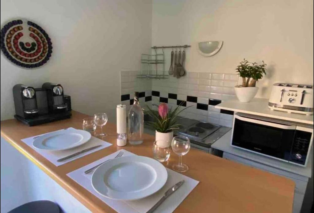 una cucina con due piatti bianchi su un bancone di Mini-Villa climatisée Porto-Vecchio a Porto Vecchio