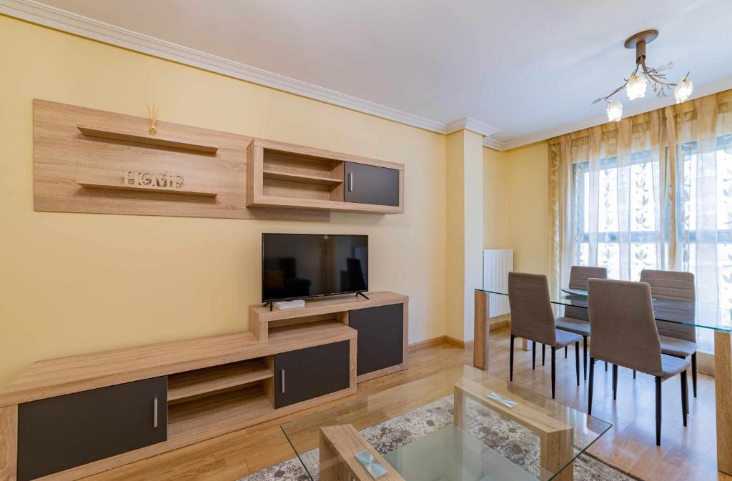 een woonkamer met een eettafel en een televisie bij Casa Morana Apartamento con garaje in Zamora