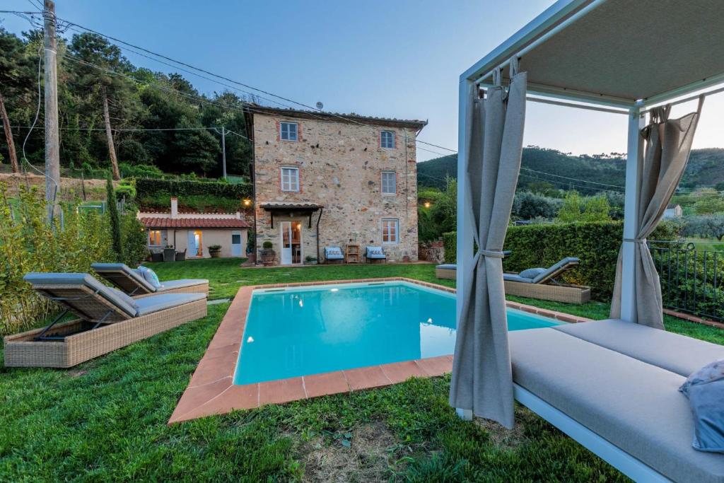 une vue extérieure d'une villa avec piscine dans l'établissement Villa Aperitivo, Romantic and Panoramic Stone Farm, à Capannori