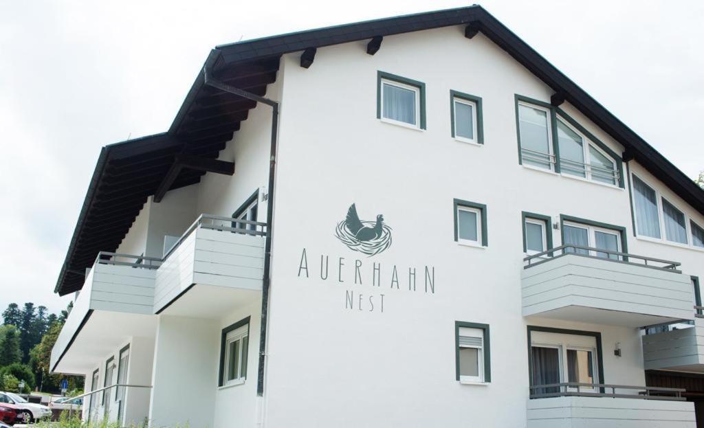 ein weißes Apartmenthaus mit einem Schild drauf in der Unterkunft Auerhahn Nest in Bad Wildbad