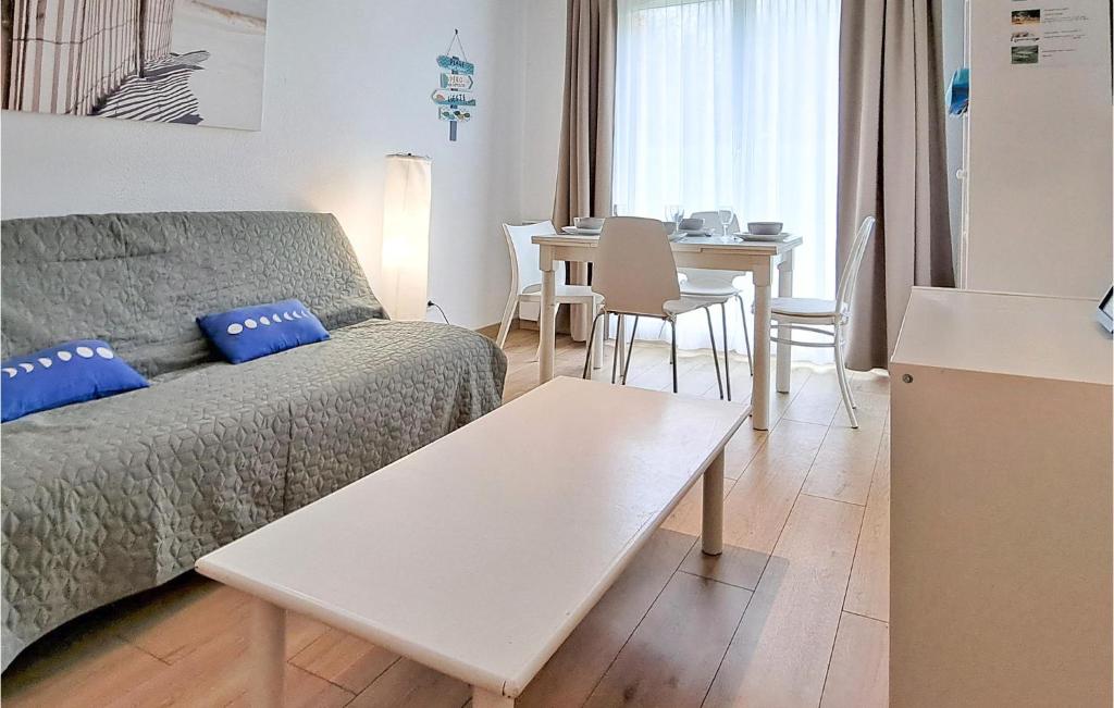 a living room with a couch and a table at Awesome Apartment In quemauville With Outdoor Swimming Pool, Heated Swimming Pool And 1 Bedrooms in Équemauville