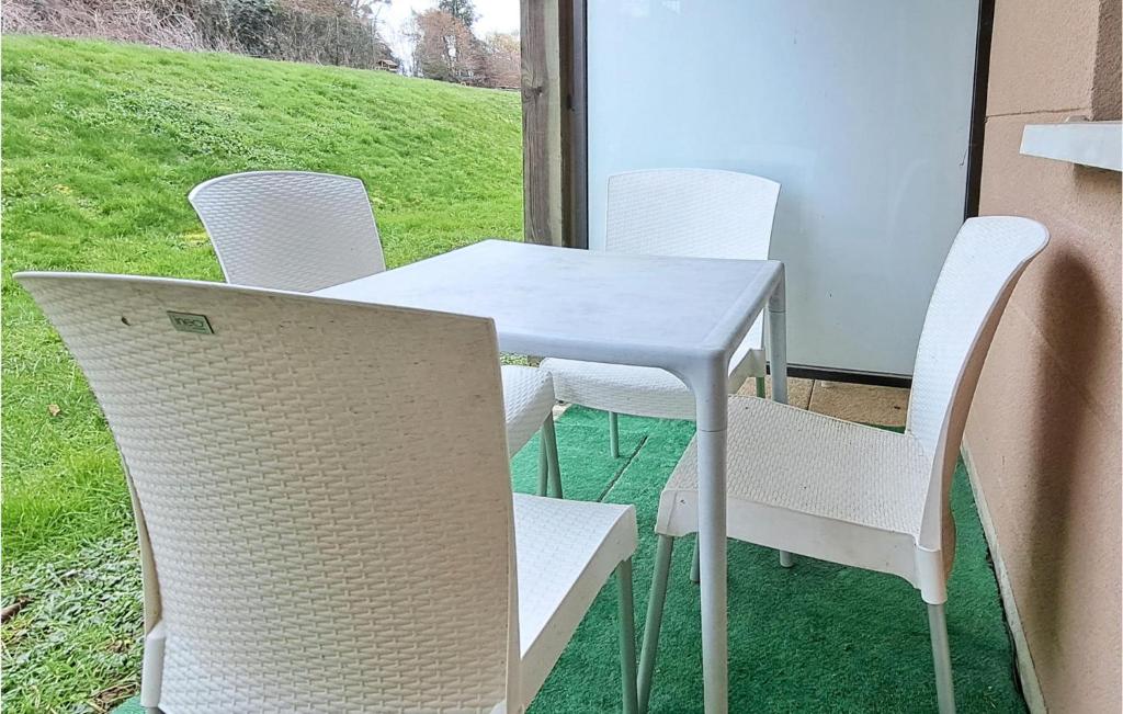 a white table and chairs with a view of a field at Awesome Apartment In quemauville With Outdoor Swimming Pool, Heated Swimming Pool And 1 Bedrooms in Équemauville