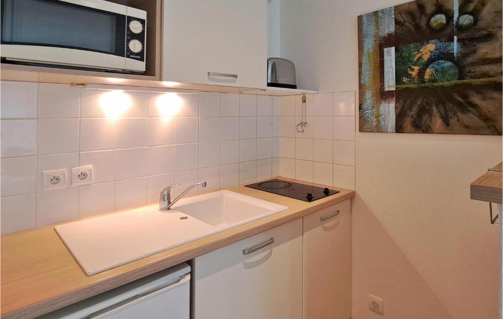 a kitchen with a sink and a microwave at Awesome Apartment In quemauville With Outdoor Swimming Pool, Heated Swimming Pool And 1 Bedrooms in Équemauville