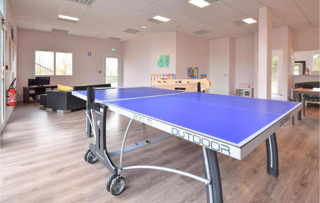 a ping pong table in the middle of a room at Awesome Apartment In quemauville With Outdoor Swimming Pool, Heated Swimming Pool And 1 Bedrooms in Équemauville