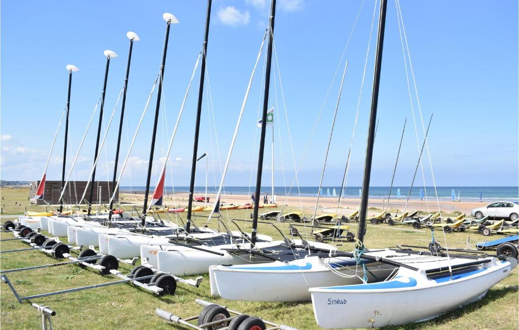 a row of sailboats are lined up on the beach at Awesome Apartment In quemauville With Outdoor Swimming Pool, Heated Swimming Pool And 1 Bedrooms in Équemauville