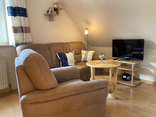a living room with a couch and a table with a tv at An der Aue 15 Wohnung Ley in Dahme
