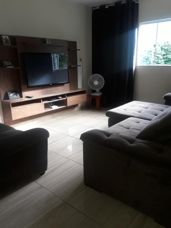 a living room with a flat screen tv and a couch at Recanto do Sossego in Alto Caparao
