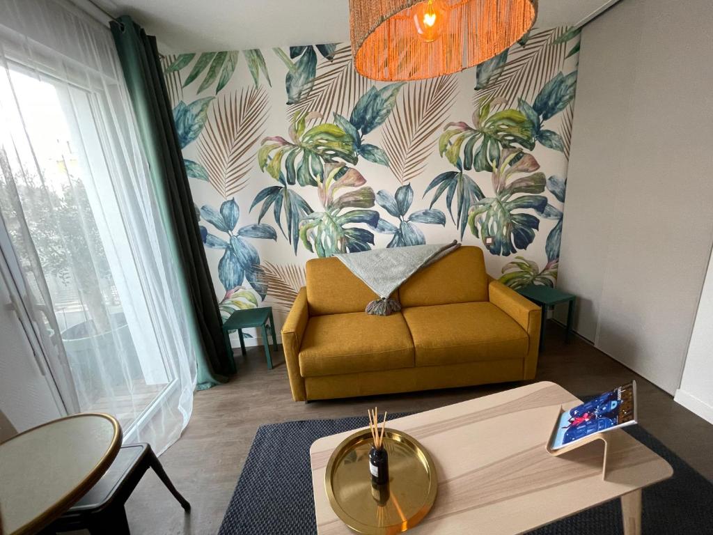 ラ・ロシェルにあるSTUDIO de charme COSY BED, LA ROCHELLEのソファとテーブルのあるリビングルーム