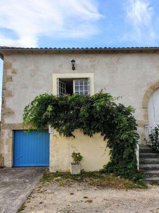 a building with a blue door and a window at Le Nid des Anges, votre studio à la campagne. in Saint-Laurent-du-Plan