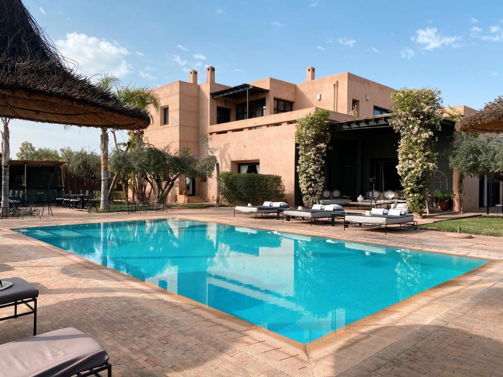 a swimming pool in front of a building at Villa Singulière By Louhou Collection in Marrakech