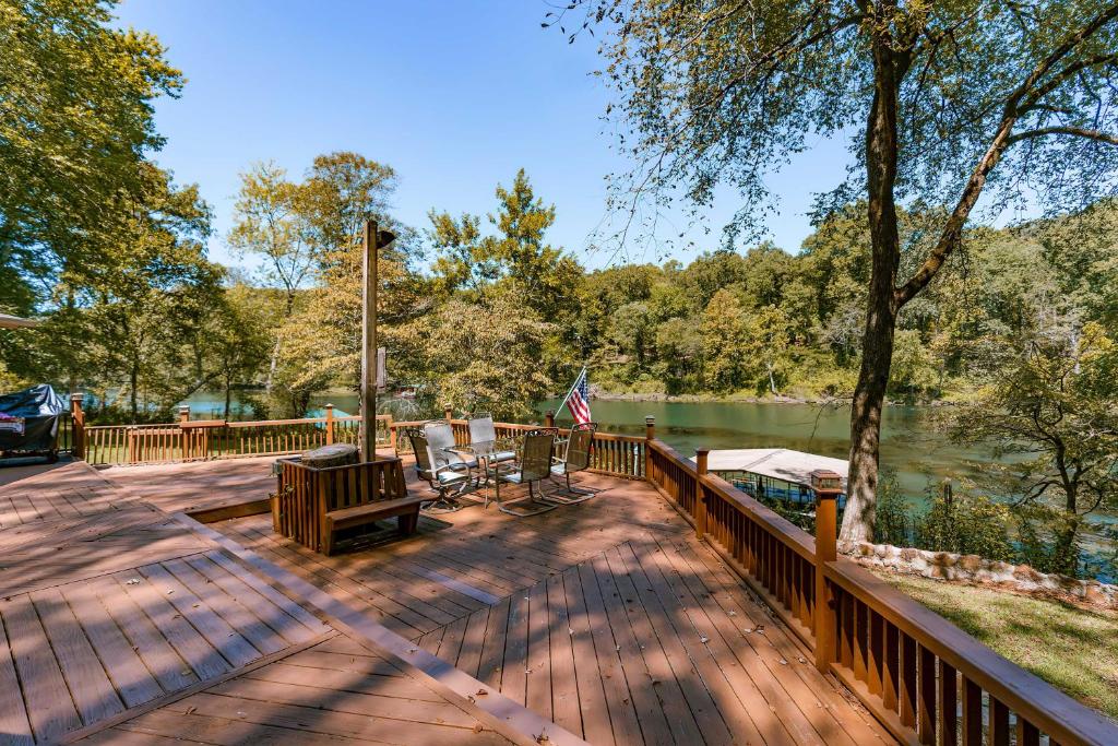 Heber SpringsRiverfront Retreat with Fire Pit Fish and Hike!的湖畔木甲板,带旗帜