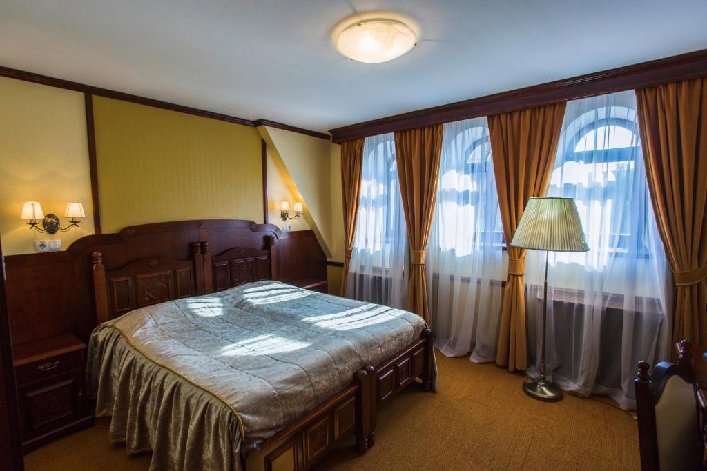una camera con un letto e due grandi finestre di Garni Hotel a Minsk