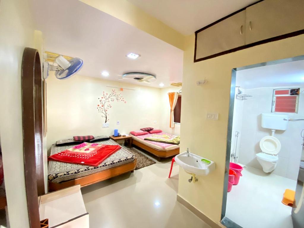 a room with two beds and a bathroom at Mayuri cottage in Mahabaleshwar