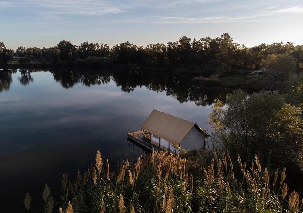 a small house on a dock on a lake at Nabi Resort Glamping & SPA in Castel Volturno