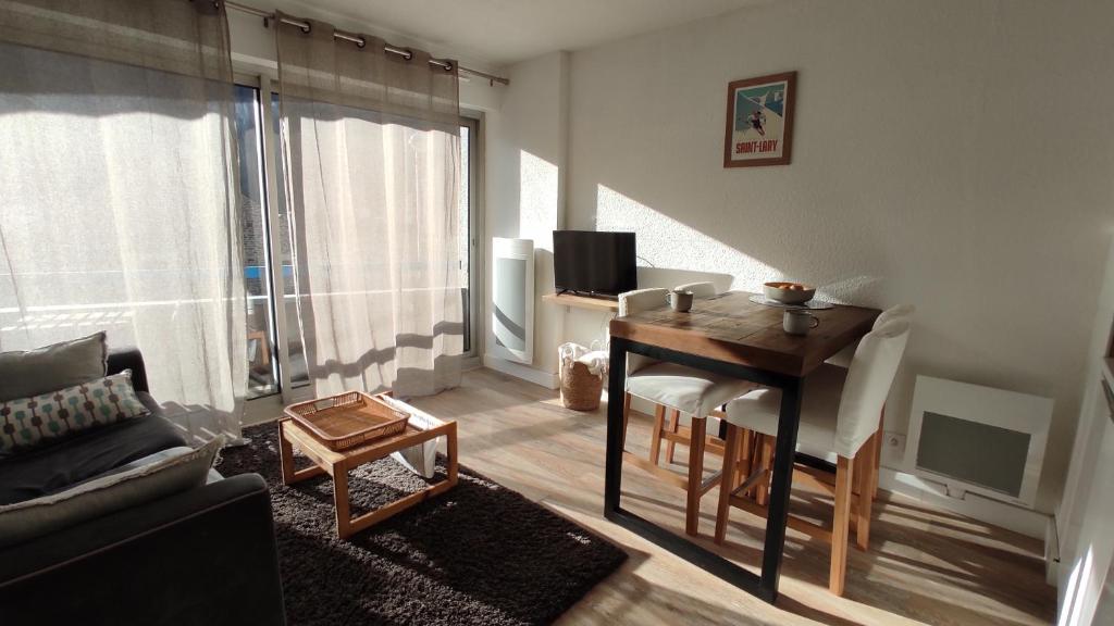 salon ze stołem i pokój z kanapą w obiekcie Appartement cosy Saint Lary village w mieście Saint-Lary-Soulan