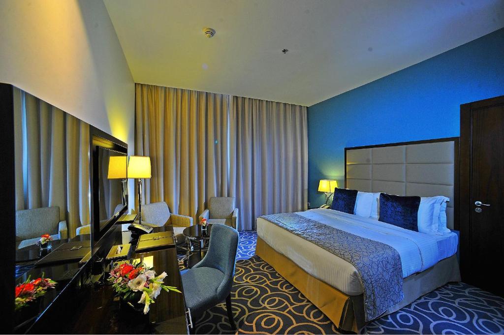 a hotel room with two beds and two lamps at Ramada Abu Dhabi Corniche in Abu Dhabi