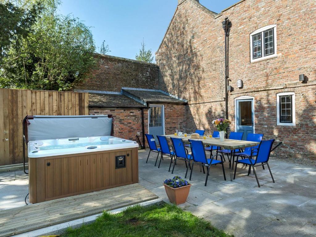 a backyard with a hot tub and a table and chairs at Islington Hall in Tilney All Saints