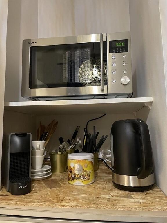 a microwave sitting on a shelf in a kitchen at STUDIO de charme COSY BED, LA ROCHELLE in La Rochelle