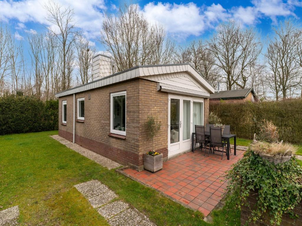 a small house on a brick patio in a yard at Modern holiday home in Baarland with terrace in Baarland