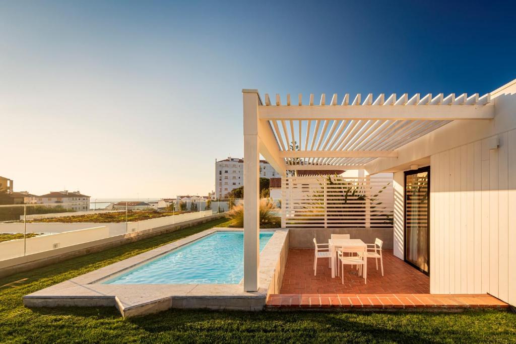 a house with a swimming pool and a pergola at Ericeira Prime Villas in Ericeira