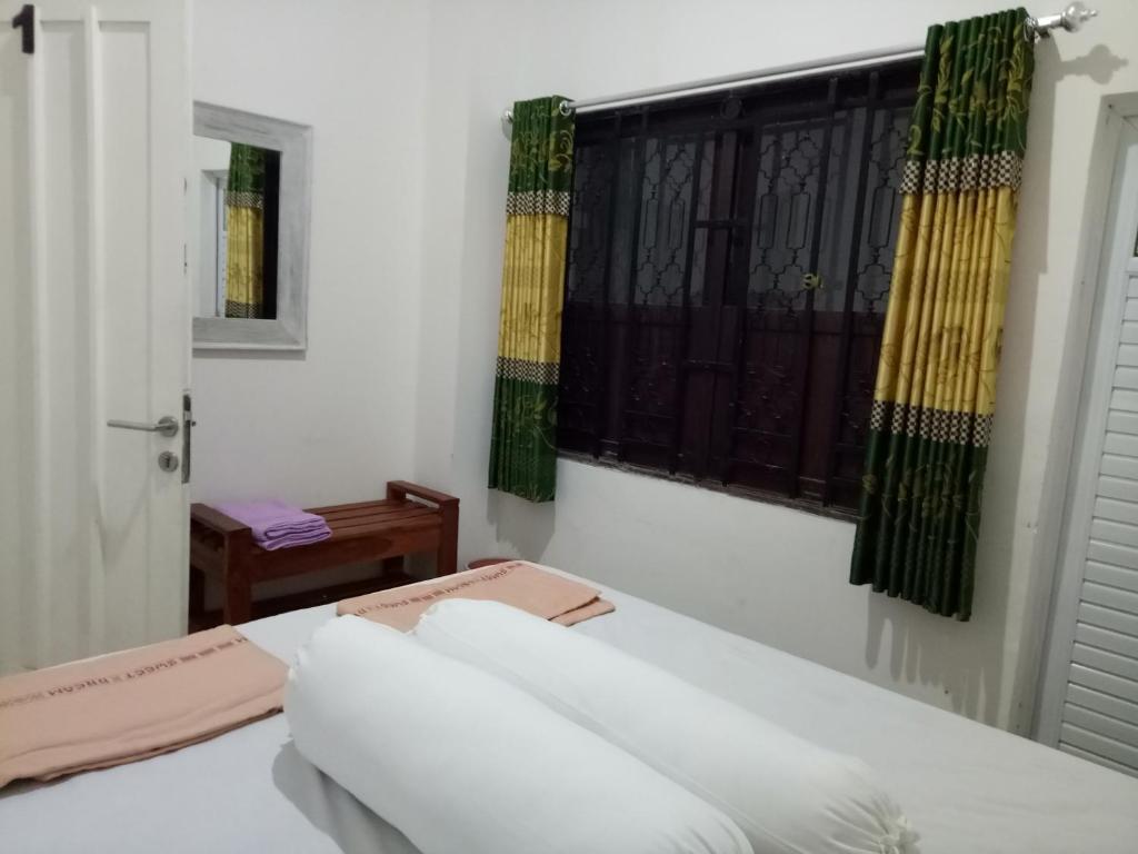 Habitación con mesa blanca y ventana en Omah Ndanu Homestay, en Yogyakarta