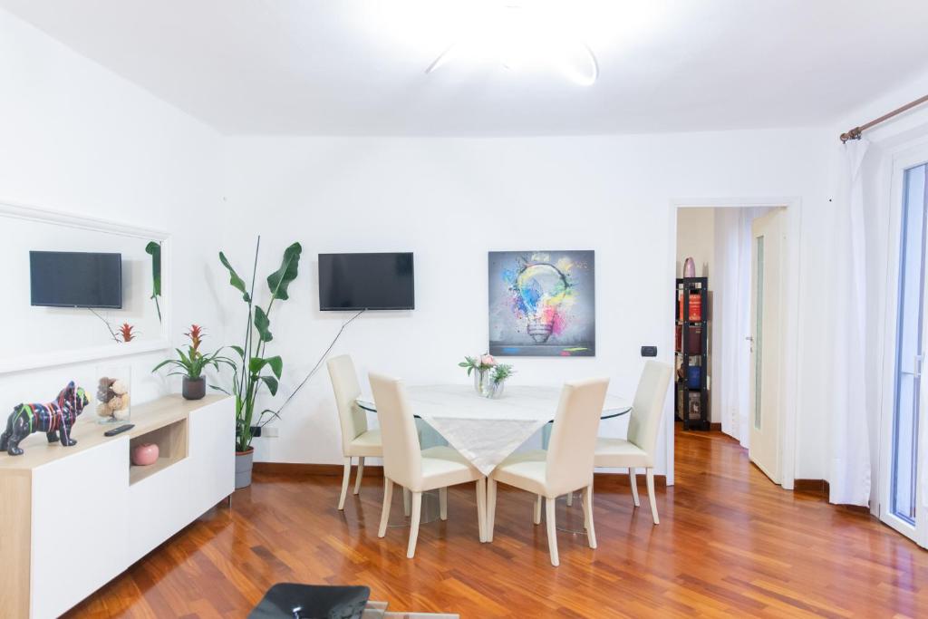 SWEET HOUSE CORSO GENOVA في ميلانو: غرفة طعام مع طاولة بيضاء وكراسي
