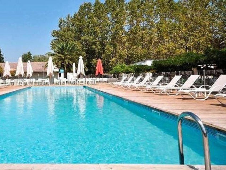 a swimming pool with lounge chairs and umbrellas at Camping U Casone - Maeva in Ghisonaccia