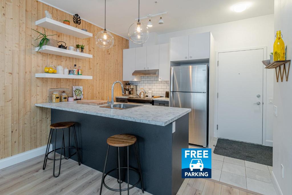 a kitchen with a counter top and a refrigerator at The Urban Oasis - Old Quebec - Gym - AC - Indoor Parking in Quebec City