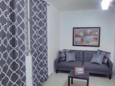 a living room with a couch and a table at Hermoso Apartamento frente Aeropuerto de Isla Verde in San Juan