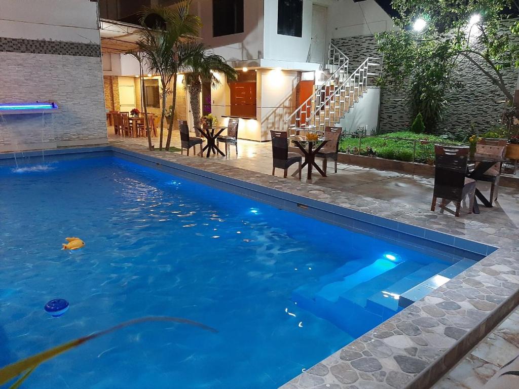 a large swimming pool with a table and chairs at La Posada 815 in Pisco