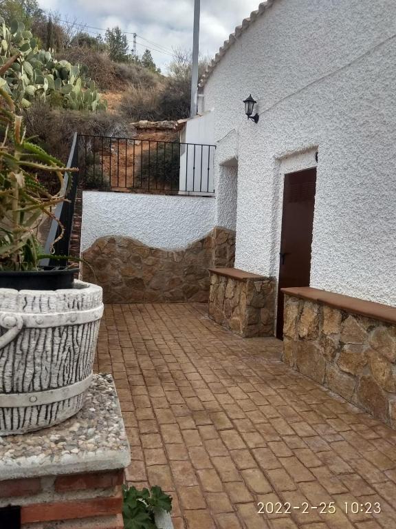 a house with a brick walkway next to a building at CASA CUEVA VANESA in Hinojares