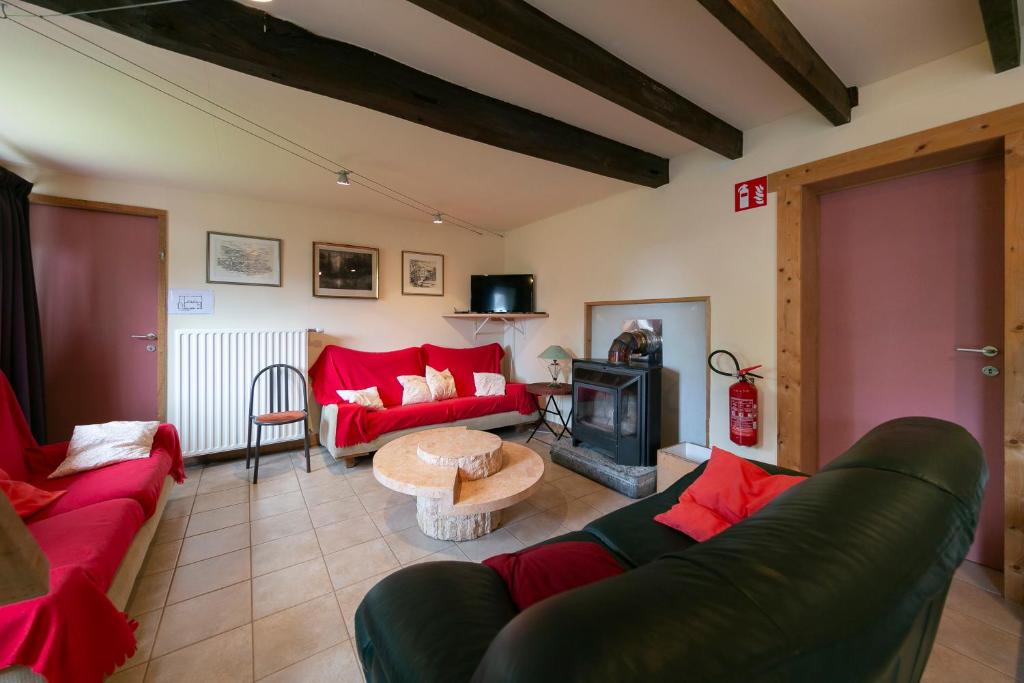 a living room with red couches and a fireplace at Landgoed Karel van Yedeghem in Watou