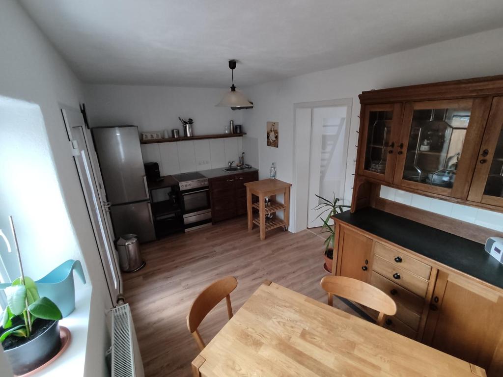 eine Küche mit einem Tisch und eine Küche mit einem Kühlschrank in der Unterkunft Ferienwohnung, Ferienapartment, Monteurwohnung, in Wittlich