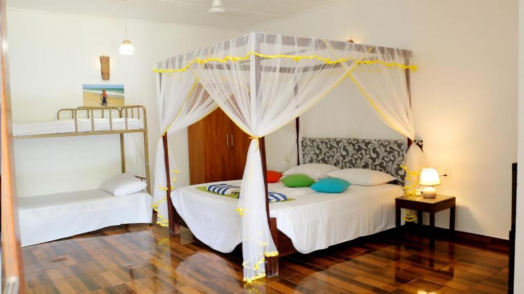 a bedroom with a bed with a canopy at FEEL Beach Villa in Kalutara