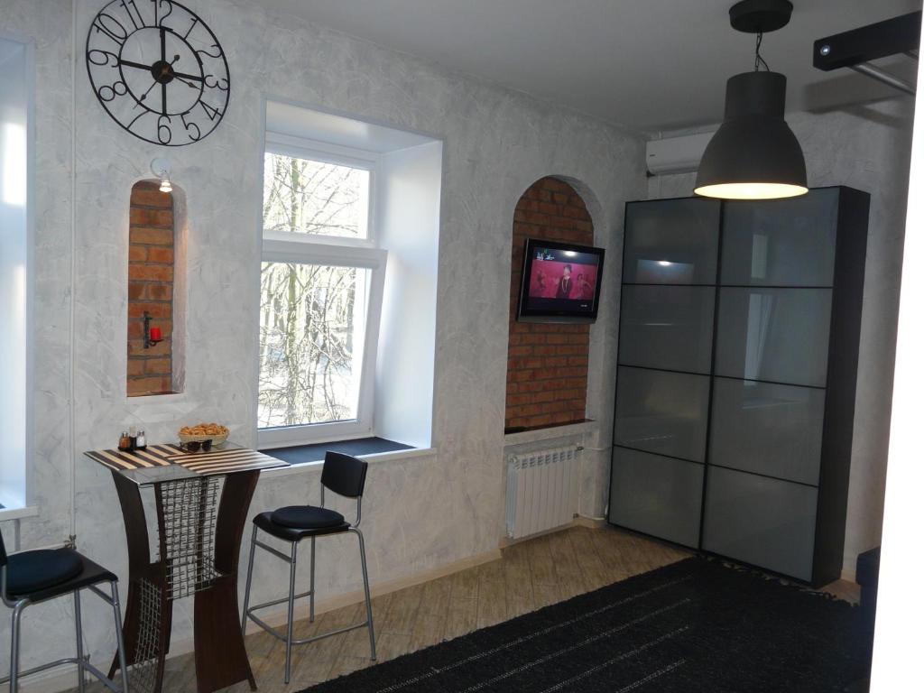 a kitchen with a table and a clock on the wall at Modern Apartments in Petergof