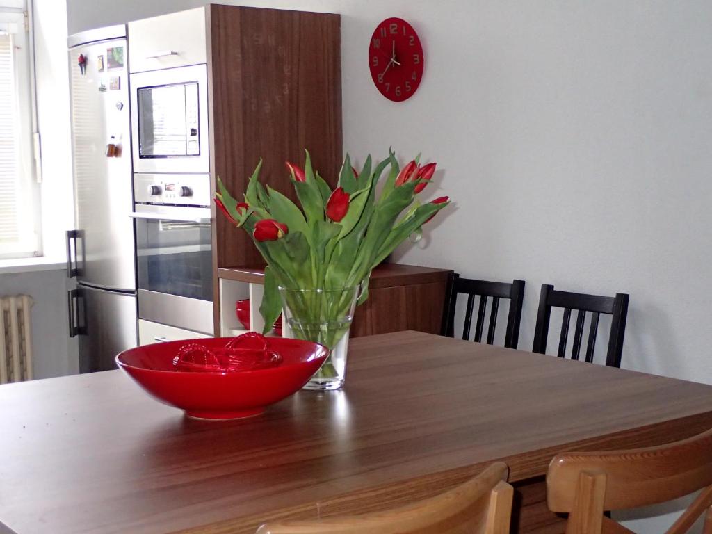 um vaso de tulipas vermelhas sentado numa mesa de madeira em Superior apartment em Bratislava