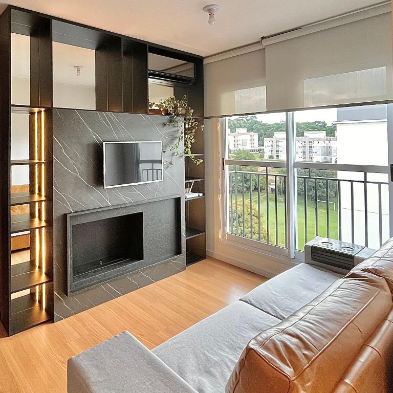 uma sala de estar com um sofá e uma lareira em Apartamento Vert808 em Lajeado