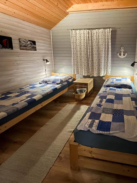 dwa łóżka w pokoju z oknem w obiekcie By The Sea Lodges w mieście Wrzosowo