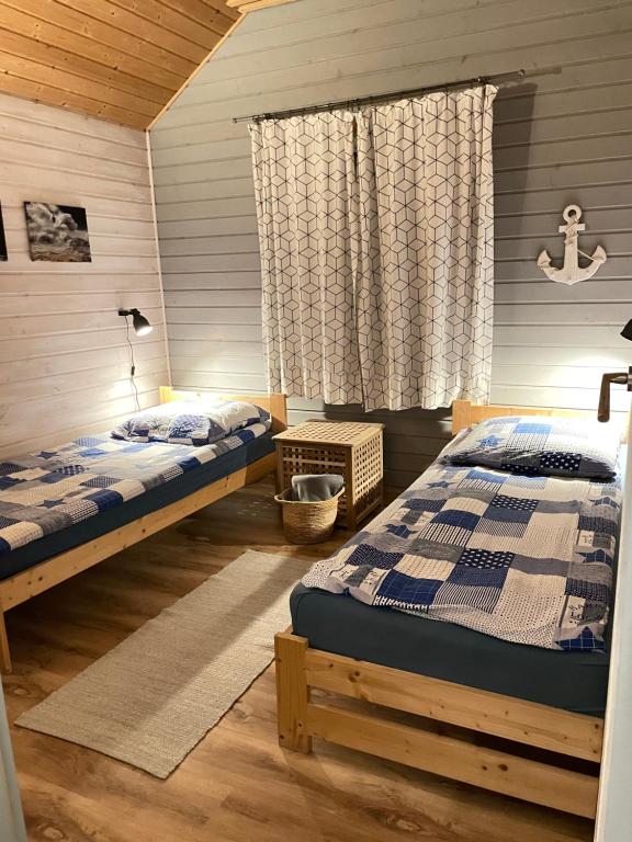 sypialnia z dwoma łóżkami i oknem w obiekcie By The Sea Lodges w mieście Wrzosowo