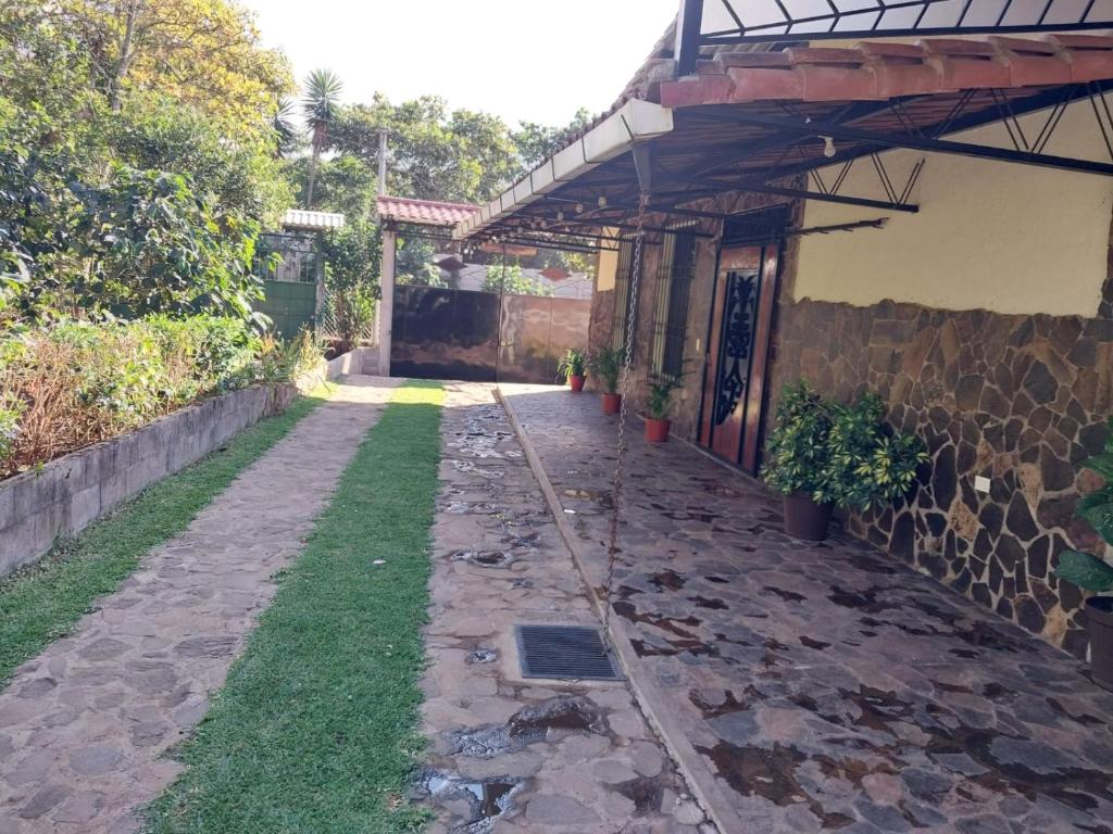 una pasarela junto a una casa con una pared de piedra en Casa de Alicia, en Concepción de Ataco