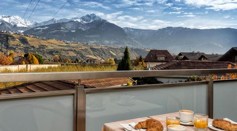 een tafel op een balkon met uitzicht op de bergen bij Residence Andrea in Lagundo