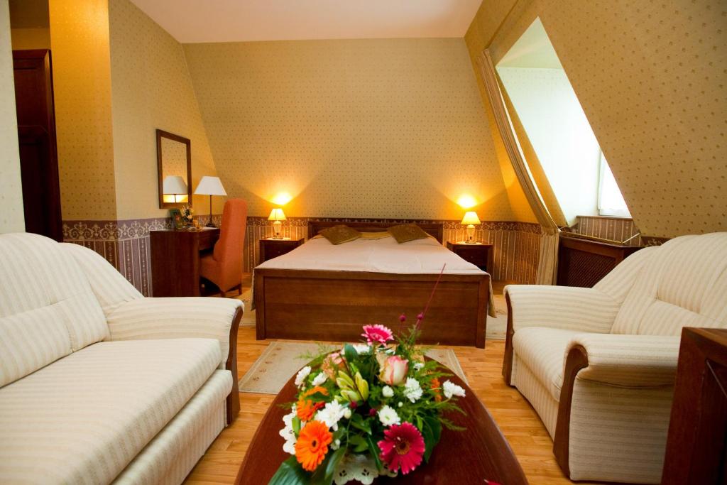 una camera da letto con un letto e un tavolo con fiori di Göcsej Palatinus Étterem és Panzió a Zalaegerszeg