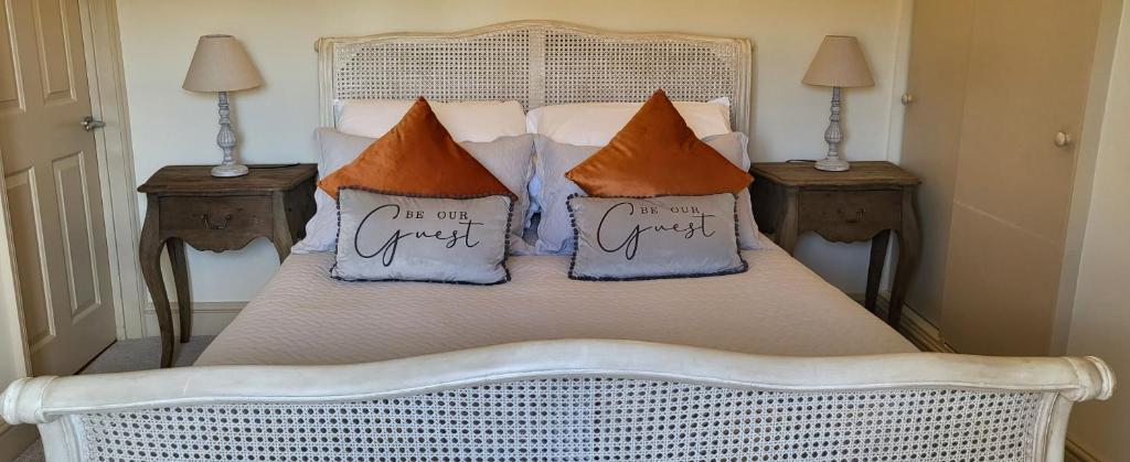 a white bed with pillows on top of it at Garden Cottage in Kelling