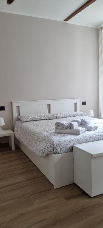 a white bedroom with a white bed and a wooden floor at The Hemme's Home in Genova