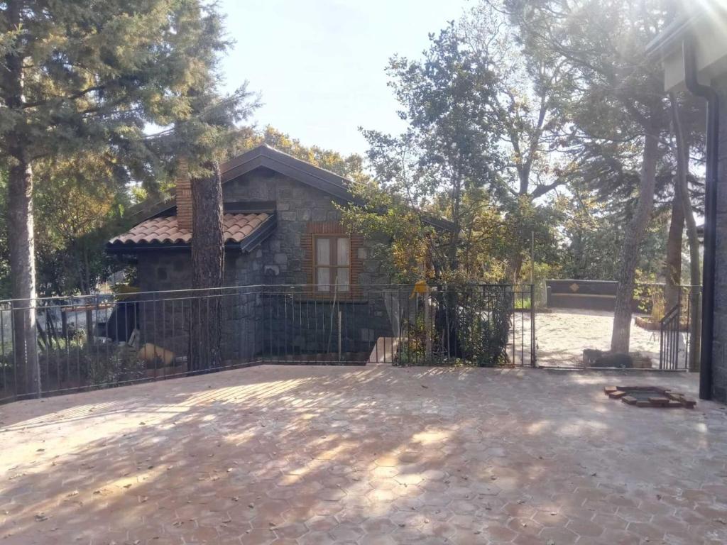 una casa con una valla delante de un patio en La dependance Etna, en Biancavilla