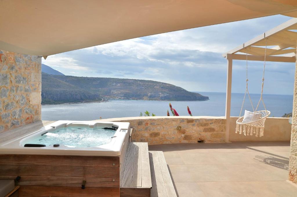 a hot tub on a balcony with a view of the ocean at Akrolithi Boutique Hotel & Suites in Oitylo