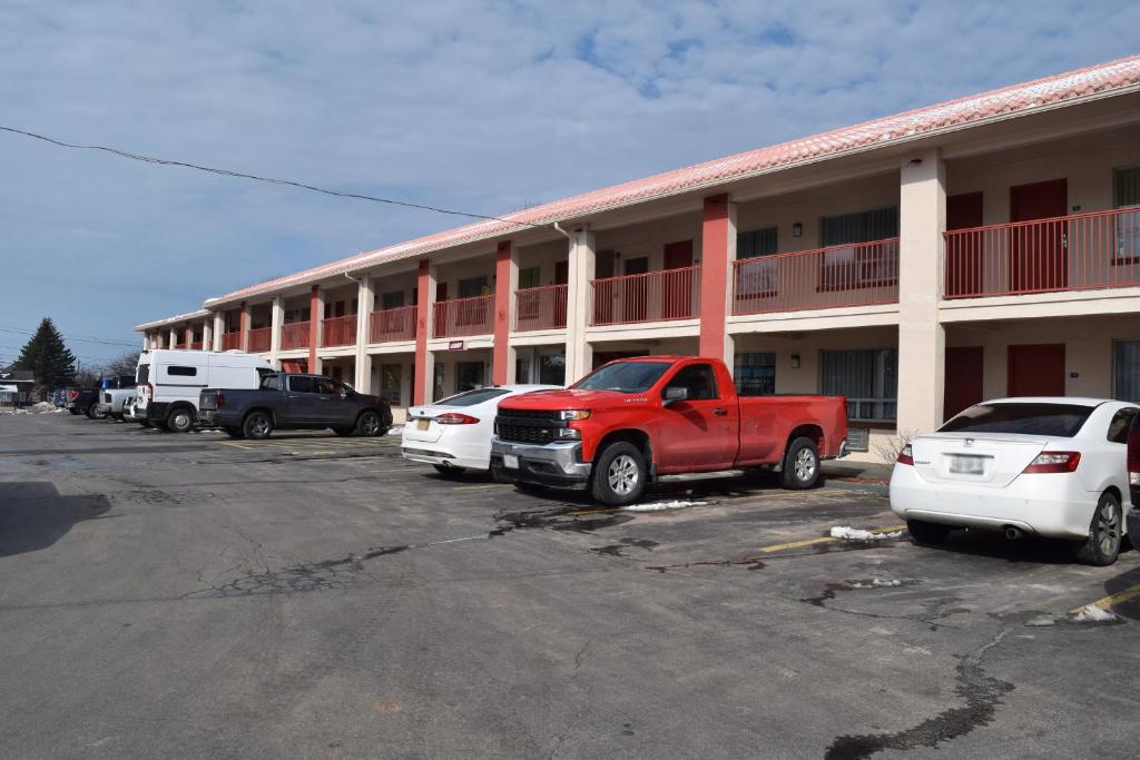 un camion rosso parcheggiato di fronte a un motel di Knights Inn Oswego East a Oswego