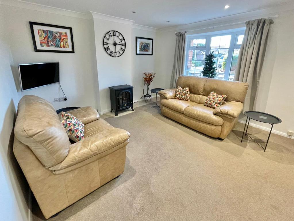 a living room with two couches and a fireplace at Bay tree Cottage Hemsley in Helmsley