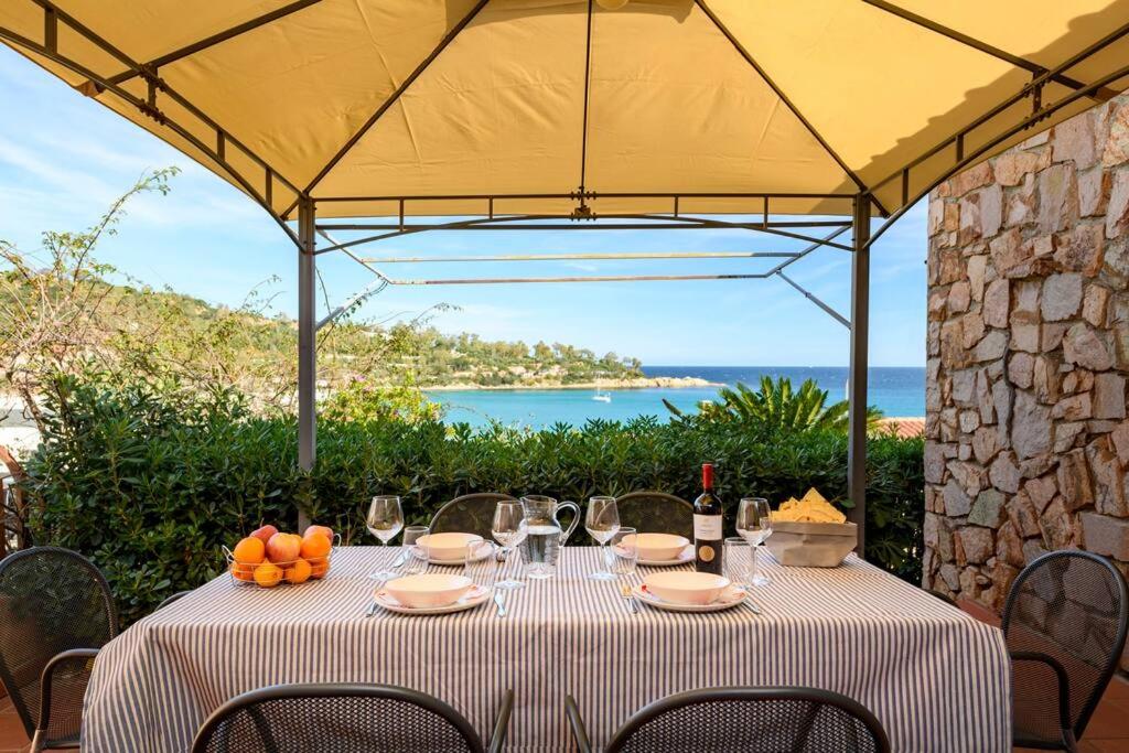 una mesa con copas de vino y fruta. en Amazing View - Exclusive Apartment Portu Frailis, en Àrbatax